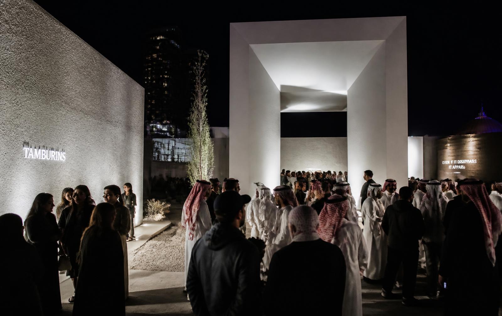 Brand activation at night in Riyadh with attendees moving through an architectural pavilion